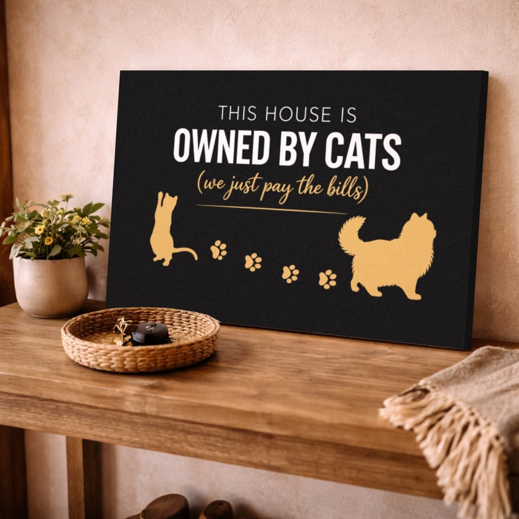 Owned By Cats canvas in Black & Gold on a wooden side table at home