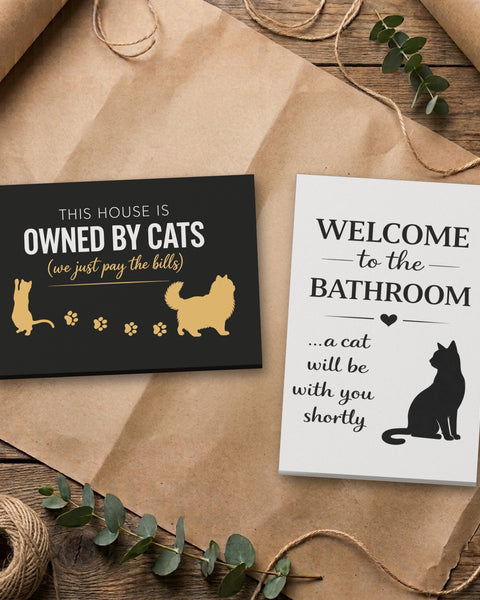 Cat canvas set, Bathroom and Black & Gold Owned By Cats, side by side on kraft paper