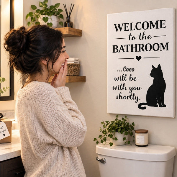 Woman delighted by a personalized cat bathroom canvas gift with the name Coco