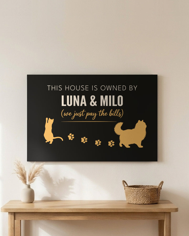 Personalized Owned By Cats canvas, Black & Gold, reading This house is owned by Luna & Milo, above an entryway table