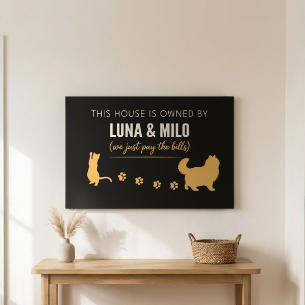 Personalized Owned By Cats canvas, Black & Gold, reading This house is owned by Luna & Milo, above an entryway table