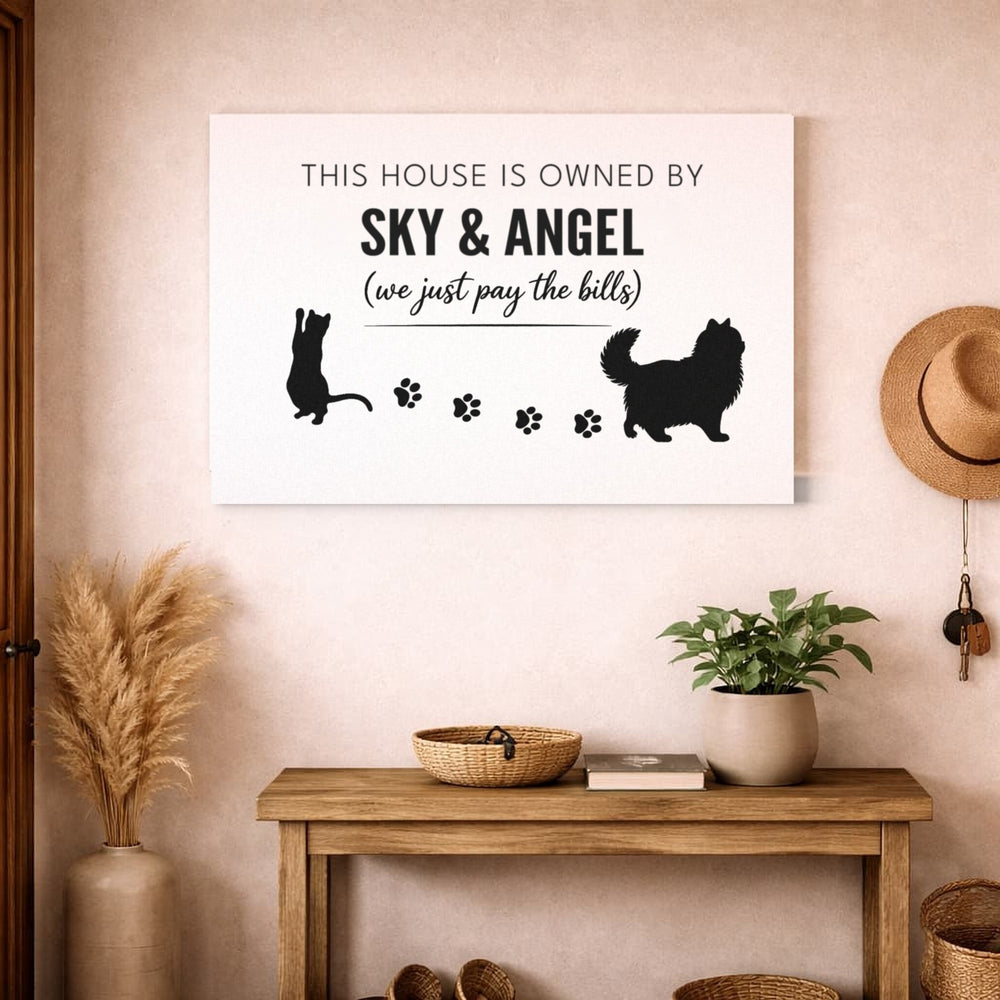 Personalized Owned By Cats canvas, White & Black, reading This house is owned by Sky & Angel, above an entryway bench