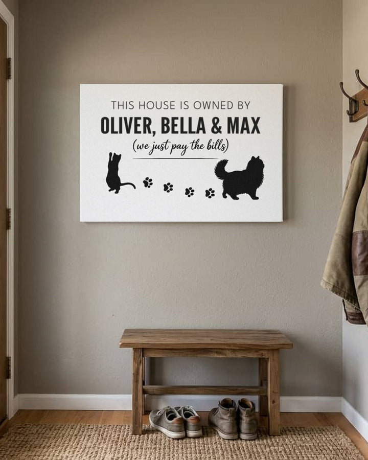 White personalized cat canvas reading This house is owned by Oliver, Bella & Max by the front door
