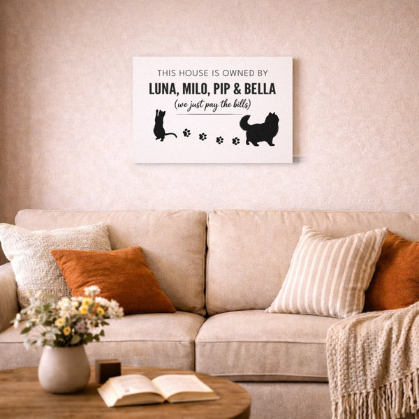 Personalized cat canvas with four names, Luna, Milo, Pip & Bella, above a living room sofa