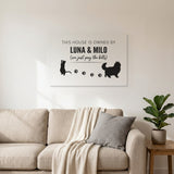 White personalized This House Is Owned By Luna & Milo canvas above a living room sofa